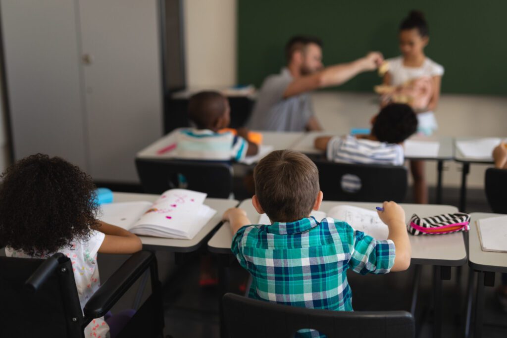 rear-view-of-schoolkids-studying-and-sitting-at-de-2025-04-03-14-16-10-utc-scaled-1